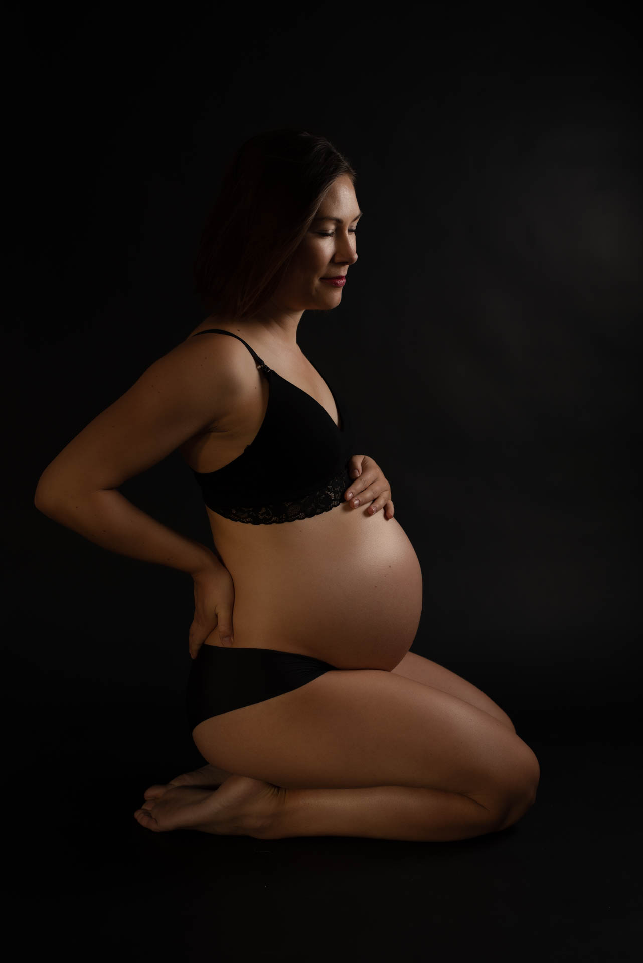 Schwangerschaftsfoto im Sitzen im Fotostudio München