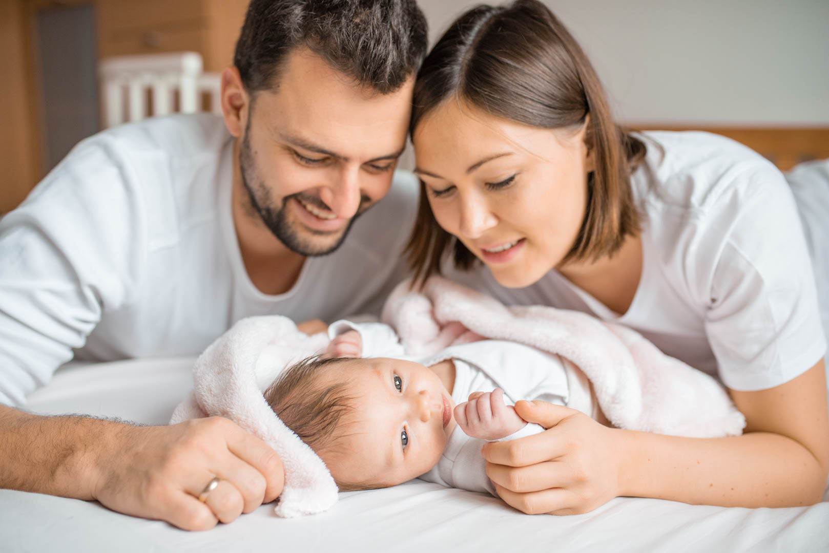 Familienfoto mit Baby zuhause auf dem Bett