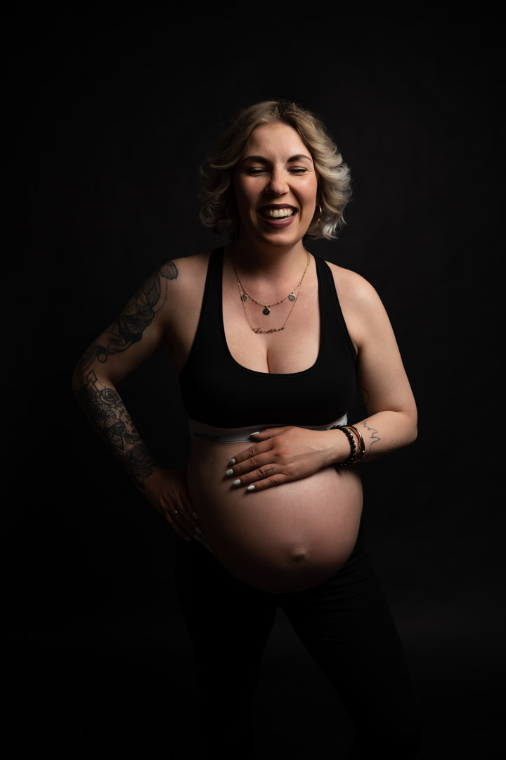 Schwangere Frau im siebten Monat im Fotostudio
